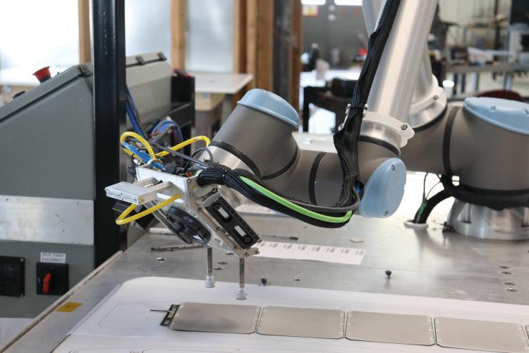 Co-bot placing Maxeon crystalline silicon solar cells to build a panel.