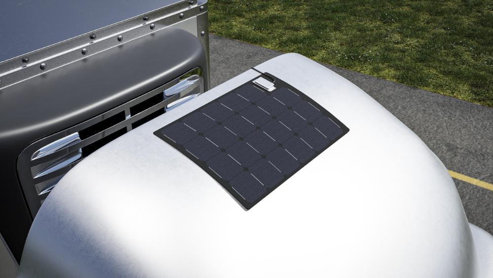 Close-up of a tractor-trailer with a daycab fairing with a flexible crystalline silicon solar panel integrated into the fairing.