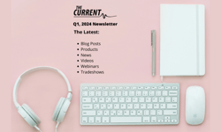 A pink desk with headphones, a keyboard, a mouse, a notebook, a pen with The Current logo, and Q1, 2024 Newsletter text.
