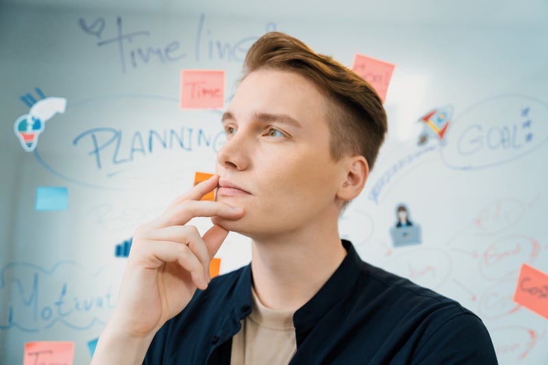 portrait-businessman-thinking-while-standing-front-board-immaculate