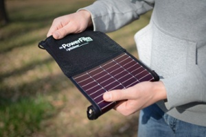 LightSaver Portable Solar Charger being unrolled by a man