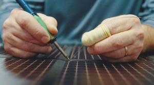 man wiring a foldable solar panel