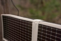 Amorphous silicon thin film foldable solar panel draped over fence