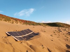 Amorphous silicon thin film solar panel unfolded on sand Amorphous silicon thin film solar panel unfolded on sand