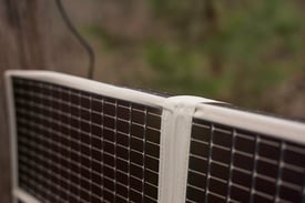 Amorphous silicon thin film foldable solar panel draped over fence