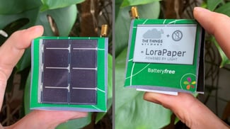 hands holding a solar powered e-paper display