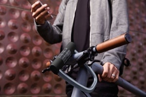 Man holding a bike with a solar powered bike lock on it